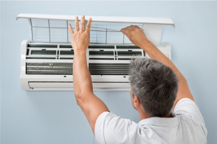 man cleaning air conditioning system